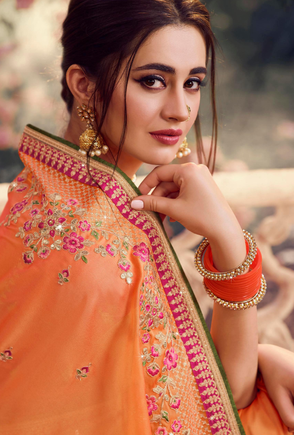 Indian woman wearing red orange traditional royal saree jewellery choker  set necklace jhumka earring maang tikka waist chain stand pose look see  smile mood expression at old rustic room background Stock Photo |